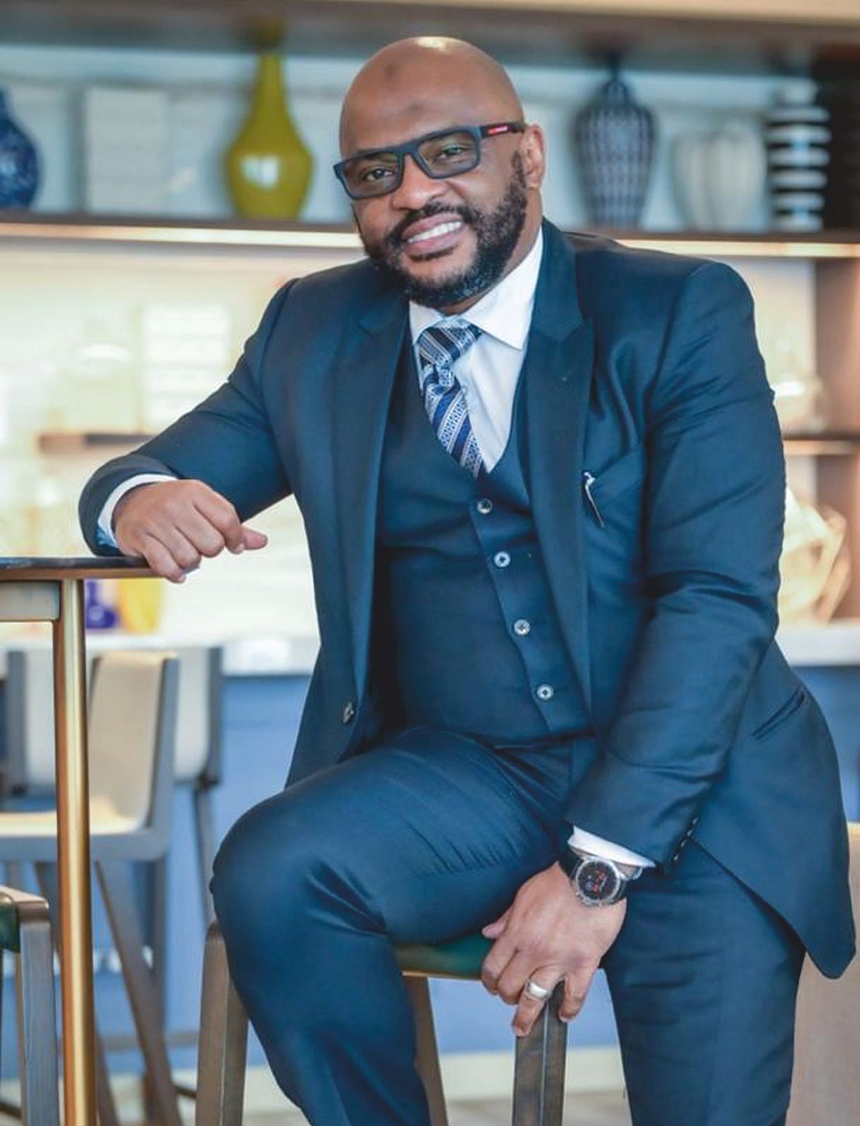 Evandro Oliveira in a navy three-piece suit